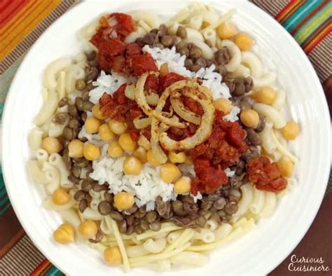 Kushari! Un trionfo di sapori speziati e una danza di consistenze irresistibili.